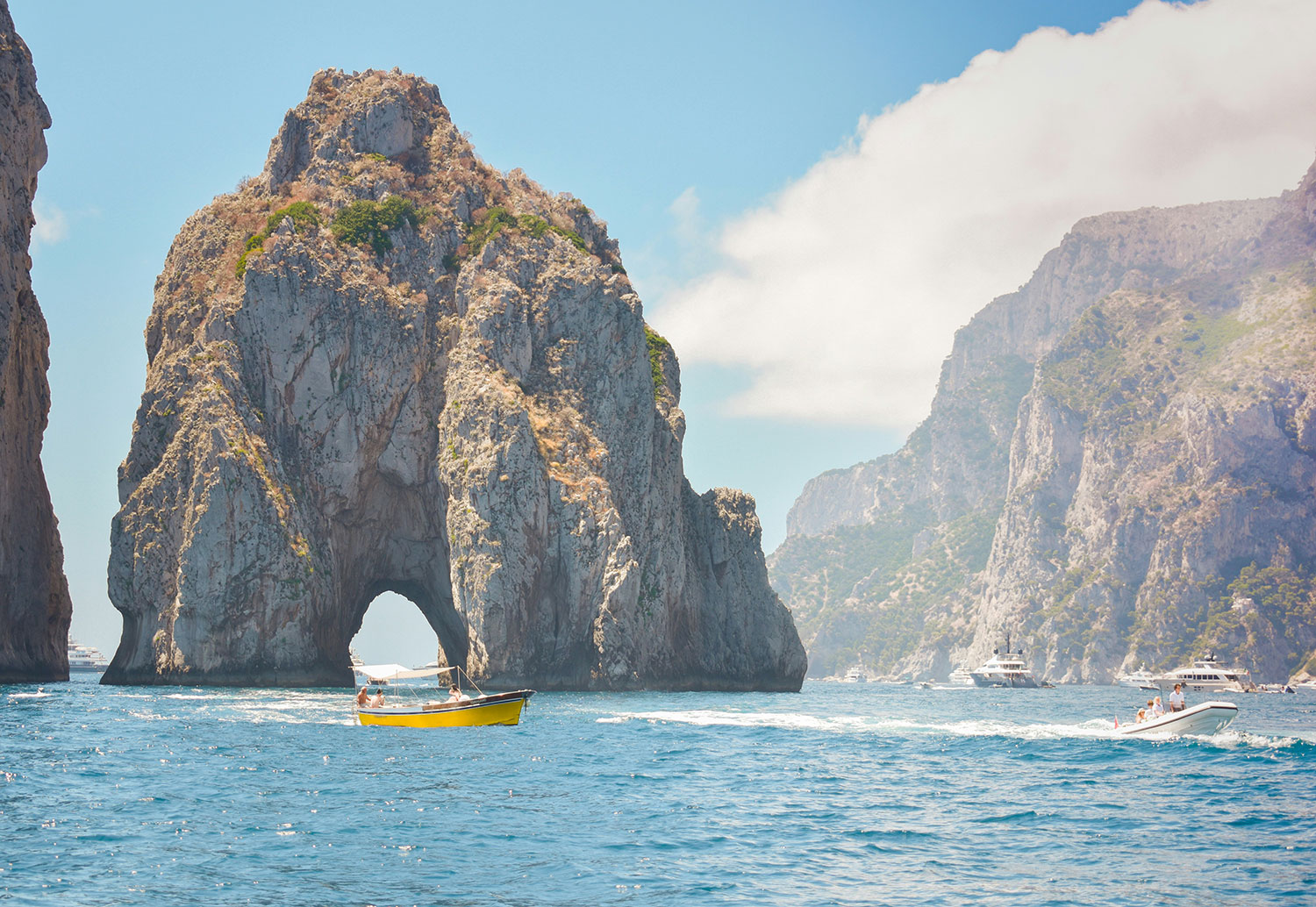 Boats passing the Faraglioni rock formations off Capri.