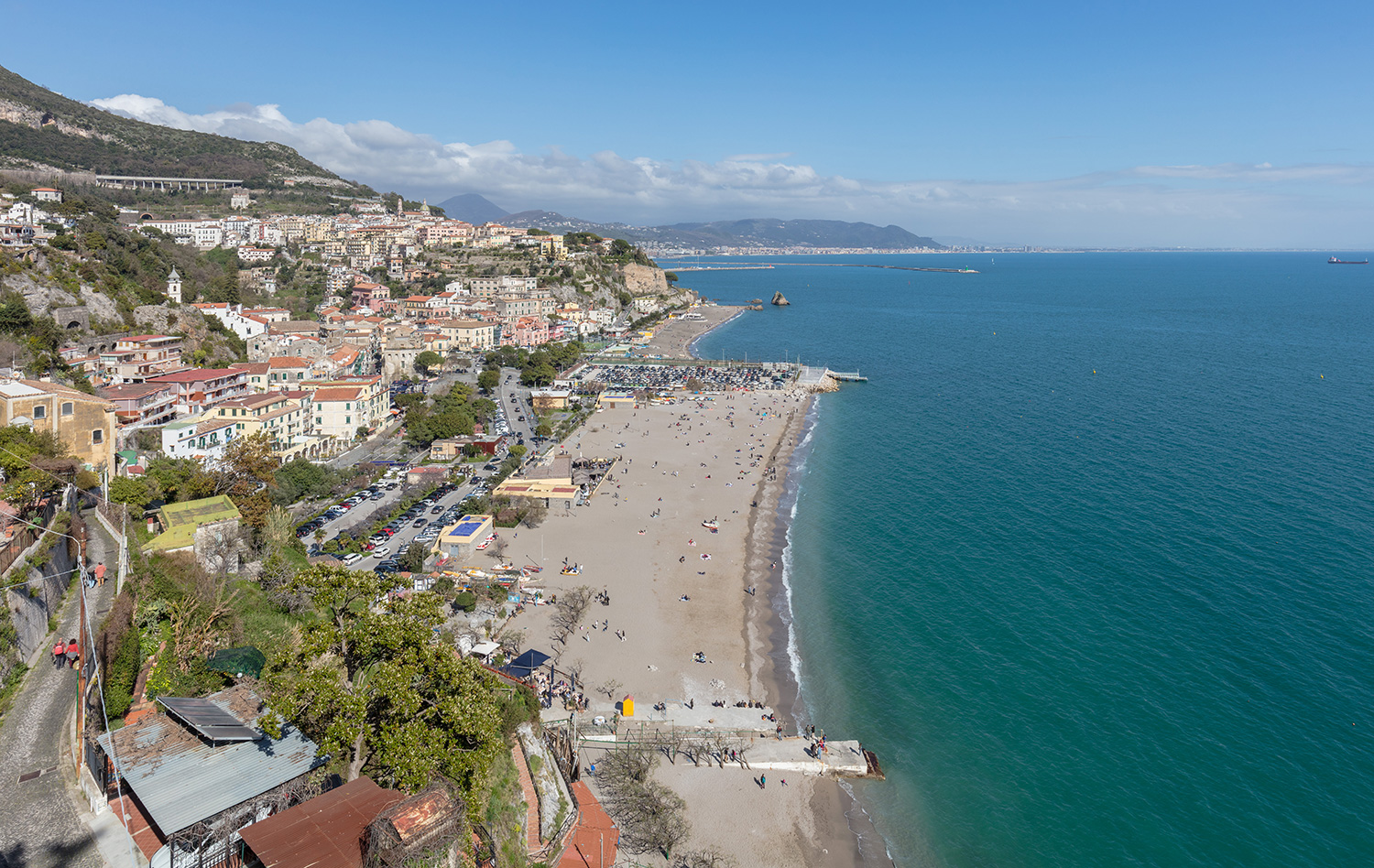 Wide view of Marina di Vietri beach with the town of Vietri sul Mare, blue sea and Salerno coastline in the distance