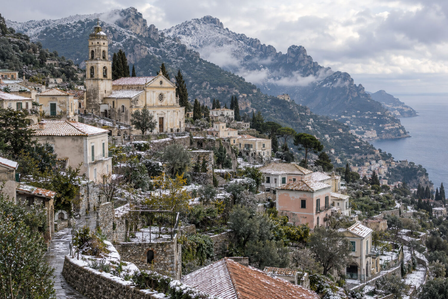 AI-generated view of Scala with a light dusting of snow on rooftops and surrounding mountains.