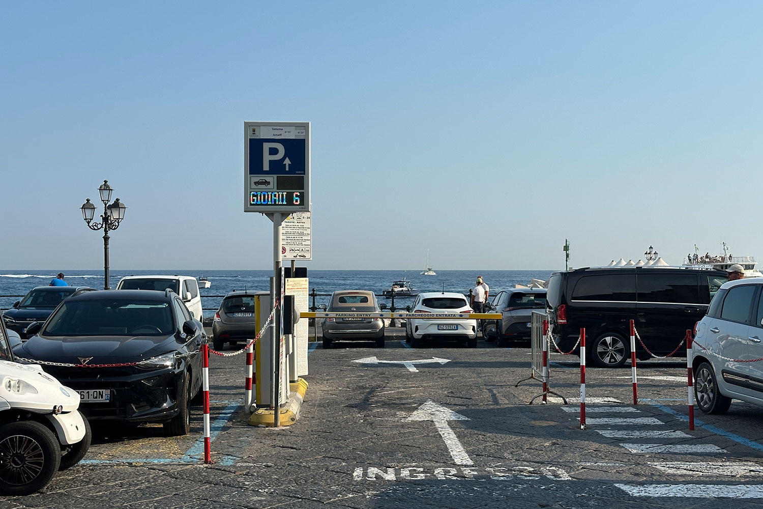 Cars parked at Darsena by the waterfront in Amalfi, Italy.