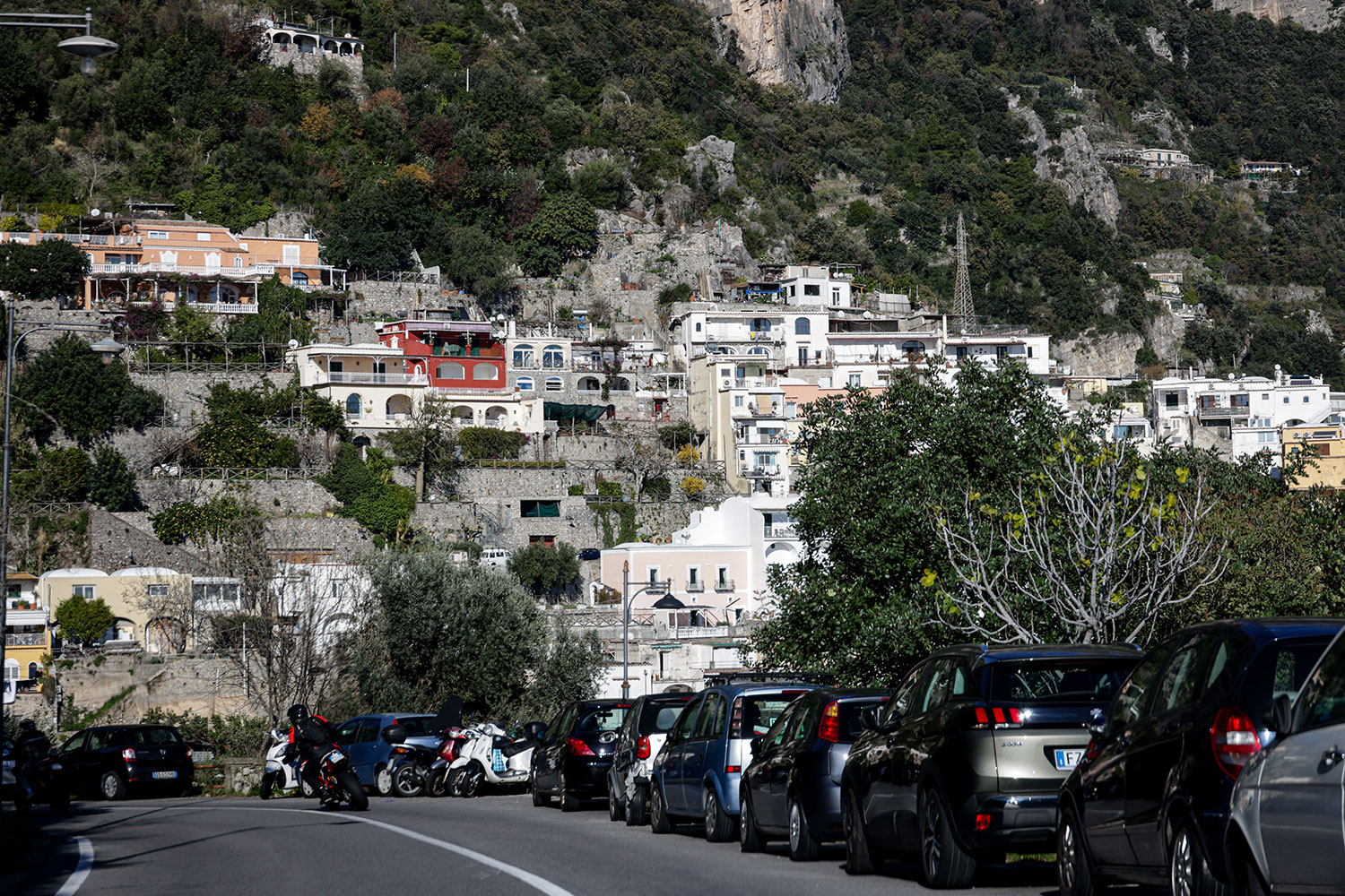 Cars parked along a roadside in Positano on the Amalfi Coast.
