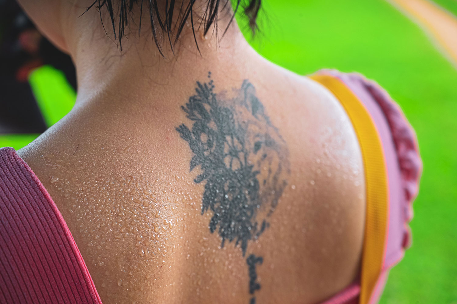 Close-up of sweat droplets on a person’s upper back and shoulders.